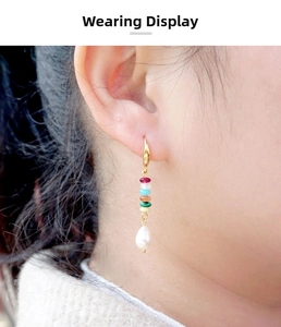 Detail view of long bohemian earrings with colorful beads and white teardrop pearls