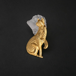 Vintage style gold cat brooch with textured detail displayed on crystal over black surface