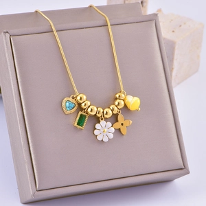 Macro view of gold snake chain with blue heart gem and white daisy enamel charms