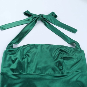 Detail eines smaragdgrünen Satin-Halterkleids mit Nackenschleife und plissiertem Mieder