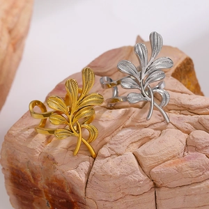 Macro detail of gold and silver leaf-shaped textured rings on natural stone