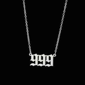 Macro detail of silver stainless steel number 999 pendant with Old English gothic font