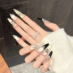 Luxury long almond press-on nails with black-gold gradient and 3D crystal bows