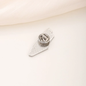 Watermelon metal pin badge back view with silver butterfly clasp on white surface
