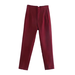 Detail of high-waisted deep red trousers featuring side pockets and a tailored straight cut