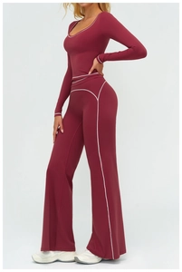 Détail de l'ensemble de yoga bordeaux avec coutures contrastées blanches et pantalon évasé
