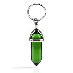 Detail of green hexagonal crystal pillar keychain with silver metal ring on white background