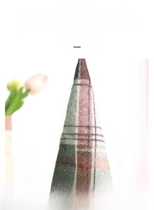 Detailed macro view of green and red plaid fabric texture on Harvest festival gnome hat