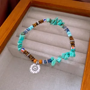 Bracelet ethnique avec perles en turquoise, oeil de tigre et pendentif de soleil