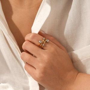 Macro view of layered stainless steel rings with gold band and silver bead details