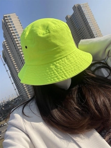 Detailed close-up of fluorescent green cotton bucket hat with stitching and vent holes