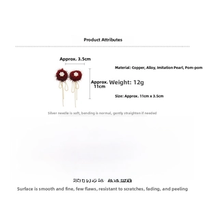Detail view of long tassel earrings with deep red pompom, faux pearls and metal chain