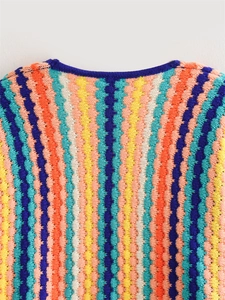 Detail of colorful hand-knitted wavy stripes and ribbed crew neck on a thick wool cardigan