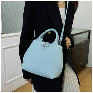 Détail du sac en cuir bleu clair grainé avec son fermoir iconique en bambou