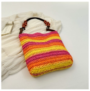 Detail of colorful rainbow woven straw tote bag with beaded wooden handles for vacation