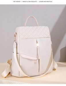 Detail view of cream nylon backpack featuring diamond quilted stitching and gold zipper