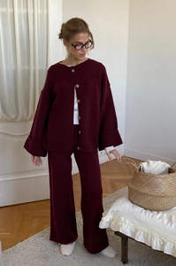 Detail of burgundy knit cardigan set with wide-leg trousers in a loose fit