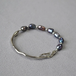 Macro detail of silver branch bracelet featuring dark baroque freshwater pearls