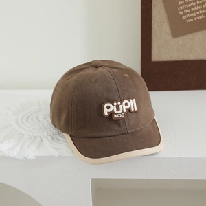 Detailed shot of dark brown kids baseball cap with PüPll KIDS patch and white piping