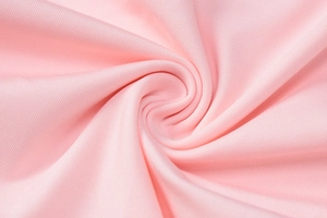 Vue macro de la texture du tissu rose montrant un motif de tourbillon pour une robe longue
