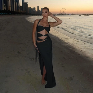 Detail of waist cut-out with metallic buckle on a black halter neck maxi dress