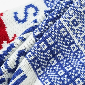 Detailed macro view of the soft knitted wool fabric with red and white geometric patterns