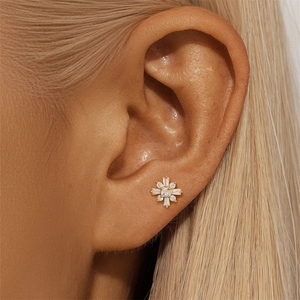 Macro shot of S925 silver flower stud earring with sparkling zircons on a golden base