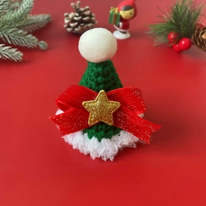 Handmade knitted Christmas hat for pets with bow and star detail on festive background