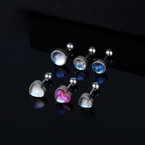 Detailed view of scorpion stud earrings with iridescent stones on black mirror background