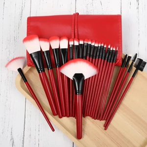 Close-up of professional 24-piece red makeup brush set with elegant leather roll bag