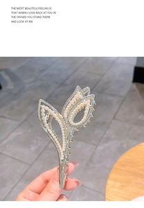 Detail of silver tulip hair claw clip with faux pearls and sparkling rhinestones