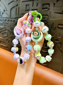 Close-up of cute colorful moon-shaped beaded phone charms and keychains with characters