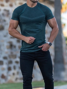 Detail of dark green athletic T-shirt showing fine mesh texture and slim fit on muscle