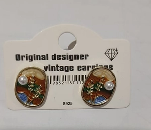 Detail of vintage enamel earrings with S925 silver pins and pearl on a white card