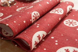 Close-up of red festive table runner showing thick woven fabric and white snowflake print