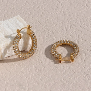 Macro view of gold plated U-shaped hoop earrings with micro-paved cubic zirconia stones