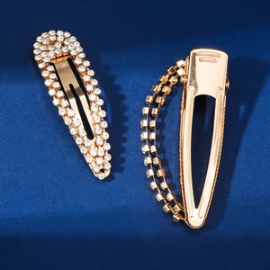 Sparkling rhinestone drop hair clips in gold finish shown on dark blue background
