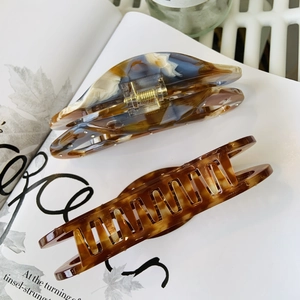 Detailed shot of acetate hair claws in tortoise and blue marble on an open book