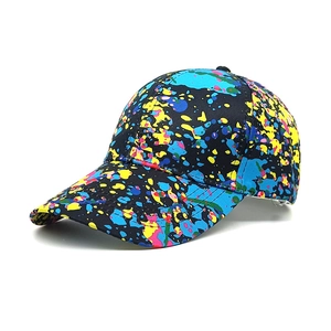 Detail of colorful paint splatter pattern on a black graffiti baseball cap with curved brim