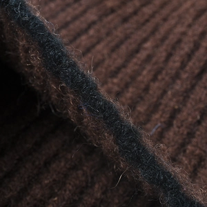 Thick rib-knit detail of a dark brown and black winter beanie with soft fiber texture