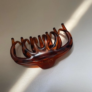 Detailed view of leopard print hair claw clip showing amber resin texture and metal spring