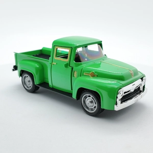 Close-up of a green vintage pickup truck toy model with chrome details on white background