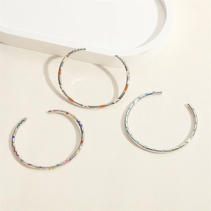 Ensemble de trois bracelets joncs en métal argenté avec motifs floraux et vagues en émail