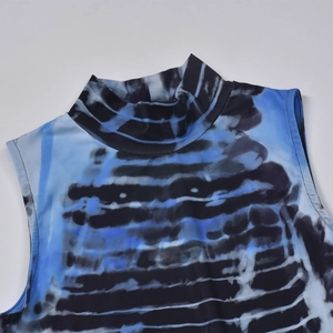 Detail of high-neck blue and black tie-dye dress with sleeveless cut and abstract pattern