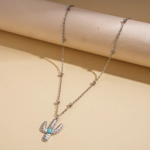 Close-up of silver cactus pendant with turquoise stone inlay on a beaded chain necklace