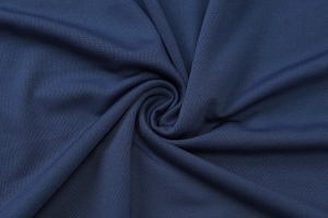Nahaufnahme von dunkelblauem Strickstoff mit spiralförmigen Falten und feiner Rippstruktur