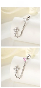 Detail of silver chain earring with heart zircon and cross stud on display stand