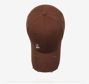 Detail of distressed brim and white embroidered basketball letters on a brown cotton cap