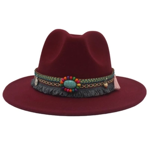 Close-up of wine red felt cowboy hat with boho turquoise beads and tassel trim detail
