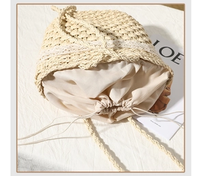 Detail of summer straw bag featuring white lace trim and secure drawstring inner lining